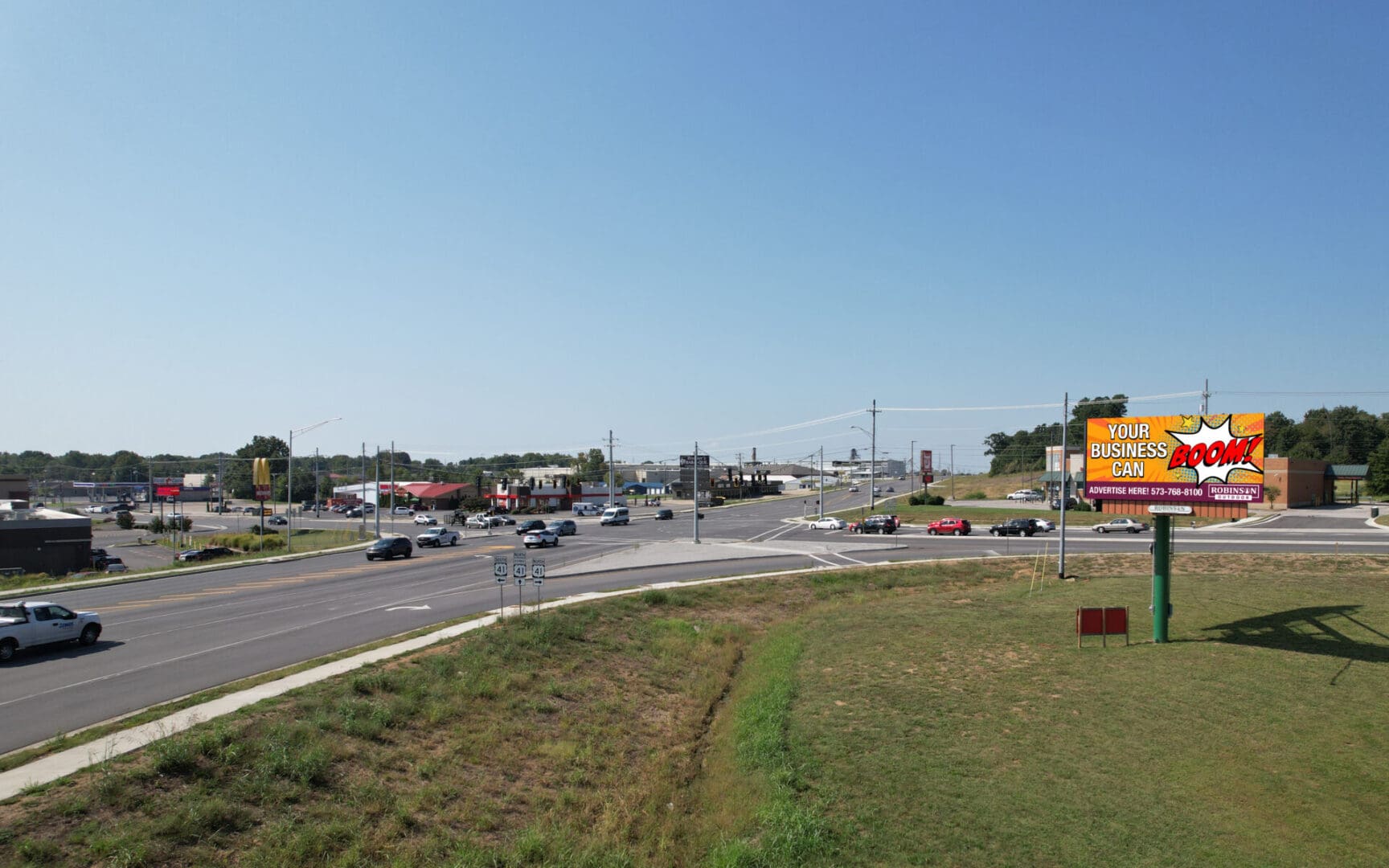 A highway with cars driving on it and some buildings