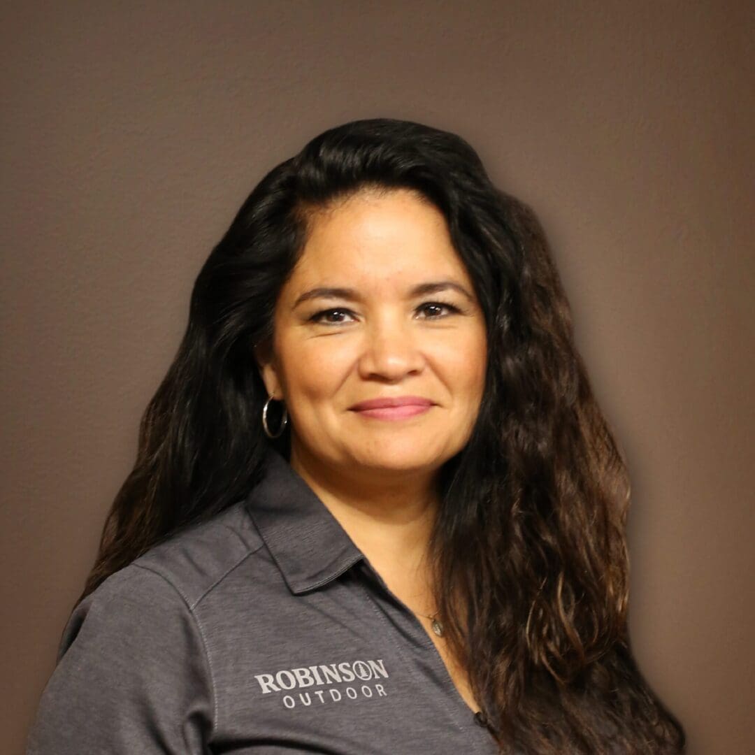 A woman with long hair wearing a gray shirt.